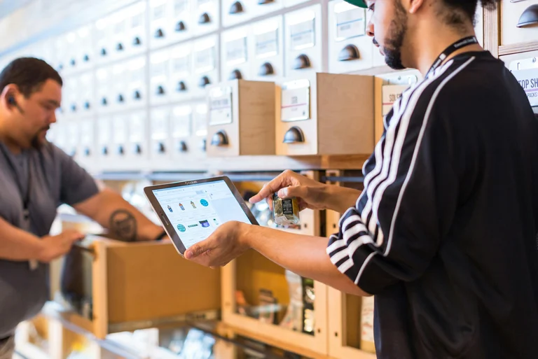 Retail staff reviewing POS data on a tablet in a store